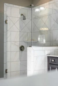 Shower tiled with white marble in diamond pattern